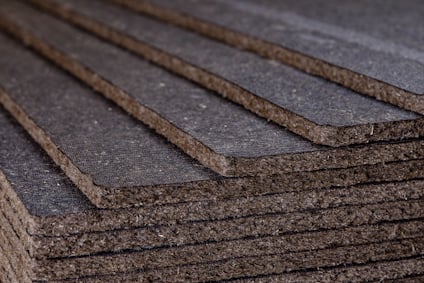 Flera lager av mörkgrå, rektangulära asfaboardplattor staplade ovanpå varandra i en sned vinkel.