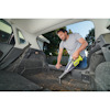 Man vacuuming car trunk with a handheld vacuum cleaner.