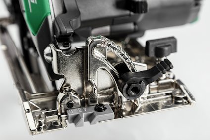 Närbild av del av elektrisk sticksåg med synliga metall- och plastdelar samt justeringsknappar.