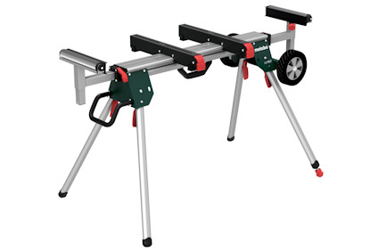 Sågbord med teleskopiska armar, fyra benstöd, handtag och hjul. Märkt med "Metabo" i grön och röd färgschema.