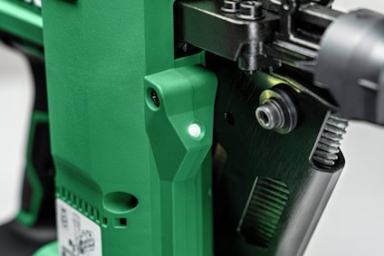 Grön och svart detalj av elektriskt verktyg med metallkomponenter.